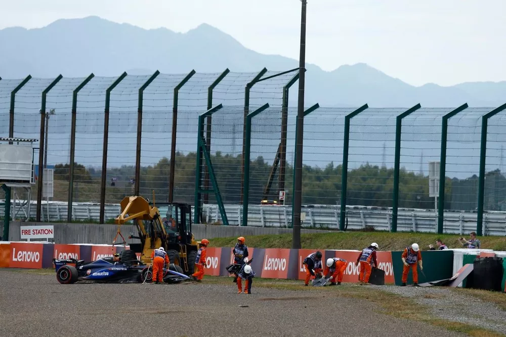 Oficiales retiran el coche dañado de Logan Sargeant, Williams FW46