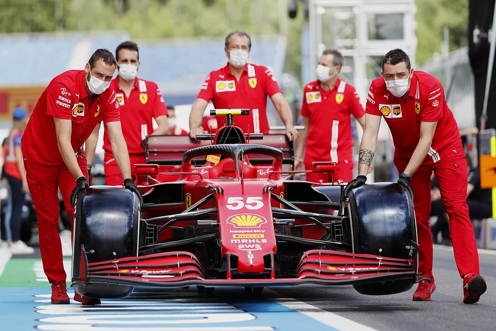 Ferrari mechanics push the car of Carlos Sainz Jr., Ferrari SF21, along the pitlane