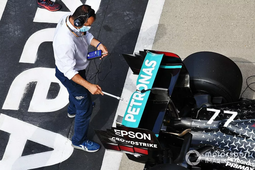 Un officiel de la FIA inspecte la monoplace de Valtteri Bottas, Mercedes F1 W11, dans le parc ferm&eacute;