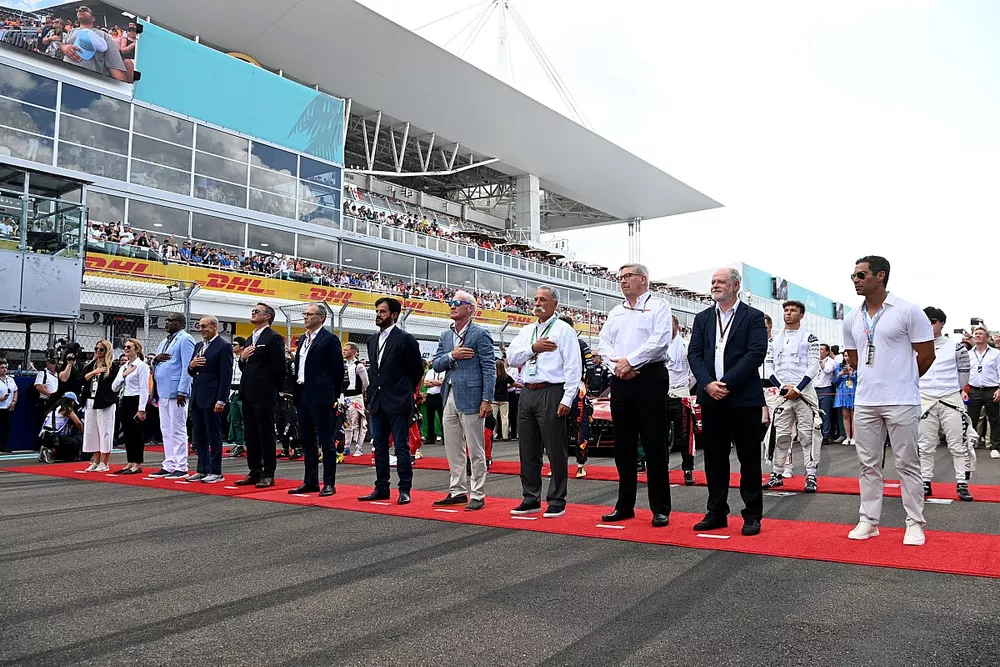 Dignitaries and drivers stand on the grid for the national anthem prior to the start