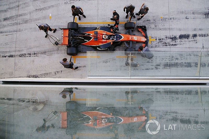 Stoffel Vandoorne, McLaren, is attended to by mechanics in the pit lane