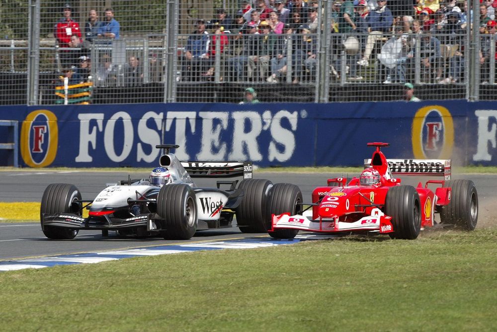 Michael Schumacher, Ferrari F2002, runs wide as he battles with Kimi Raikkonen, Team McLaren Mercedes MP4/17D