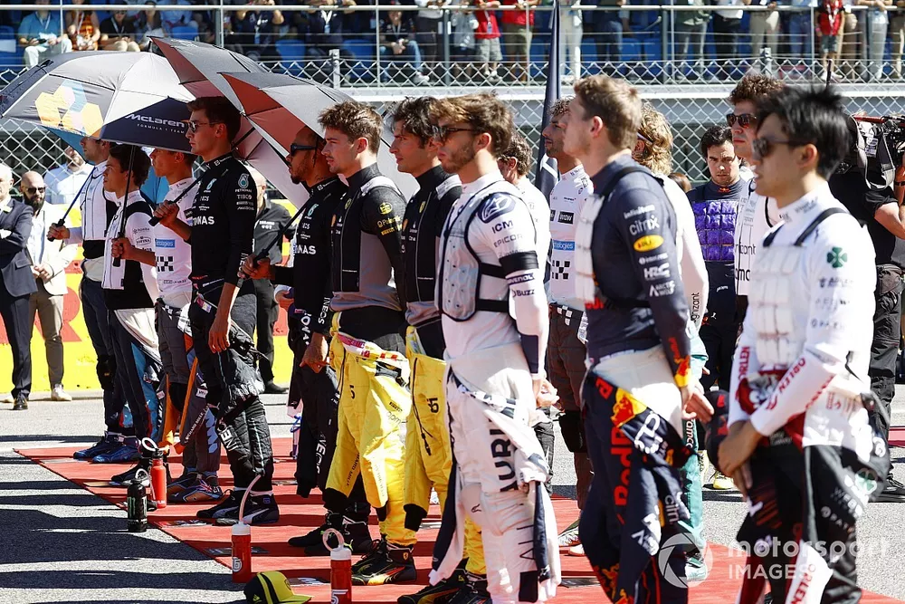 The drivers stand on the grid for the national anthem prior to the start