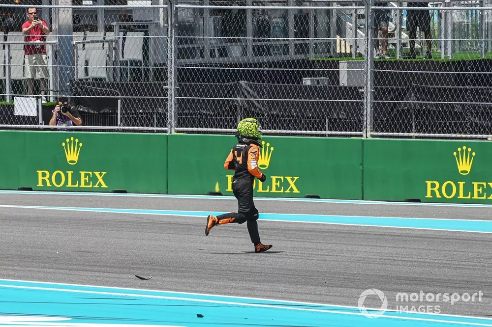 Lando Norris, McLaren MCL38, crosses the track on foot after a crash on the opening lap