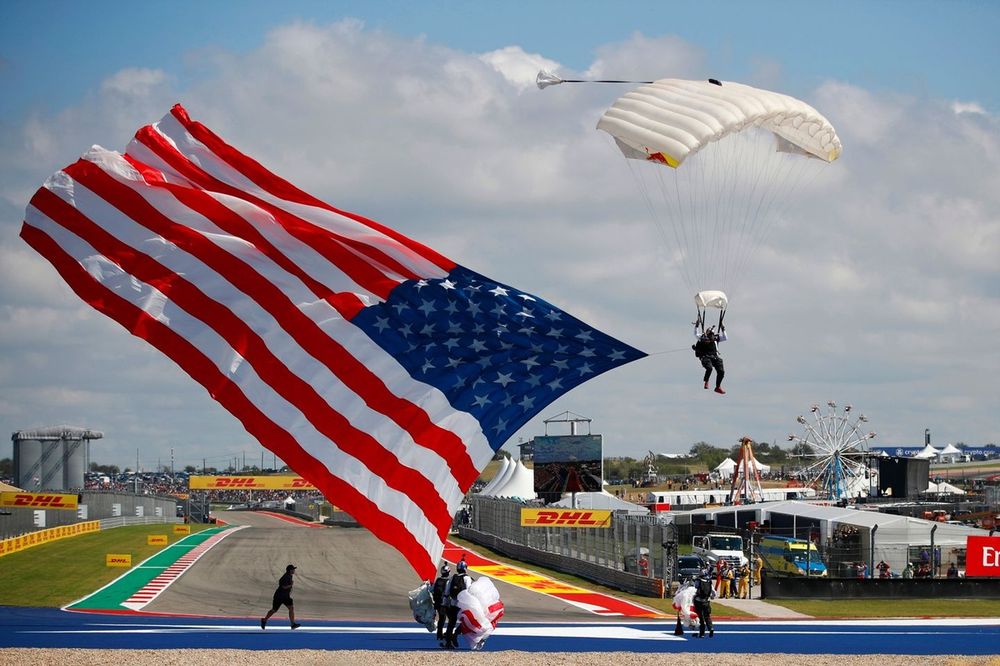 Un paracaidista llega con una bandera estadounidense