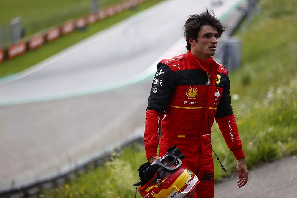 Carlos Sainz, Ferrari, walks away from his car after a fire