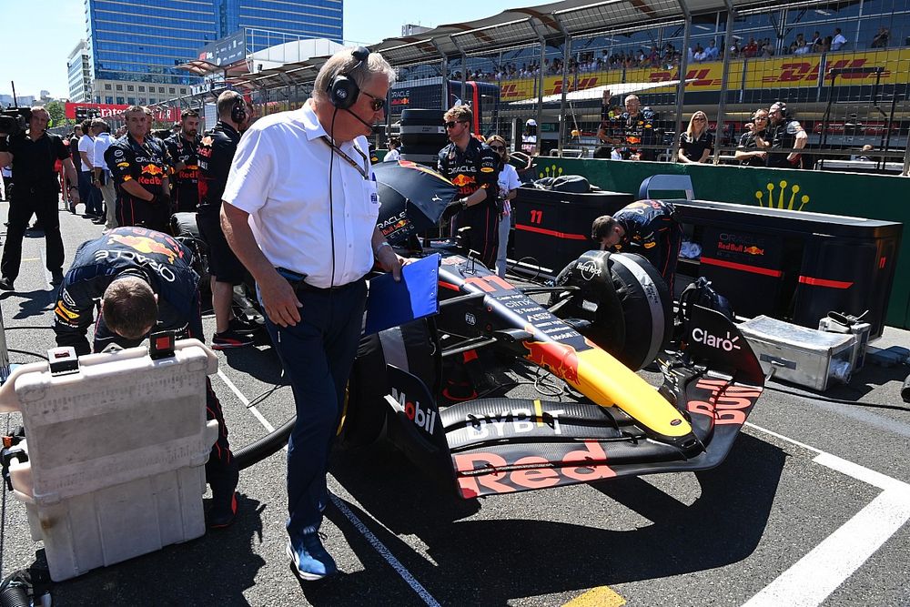 Un funcionario de la FIA en la parrilla con el coche de Sergio P&eacute;rez, Red Bull Racing RB18