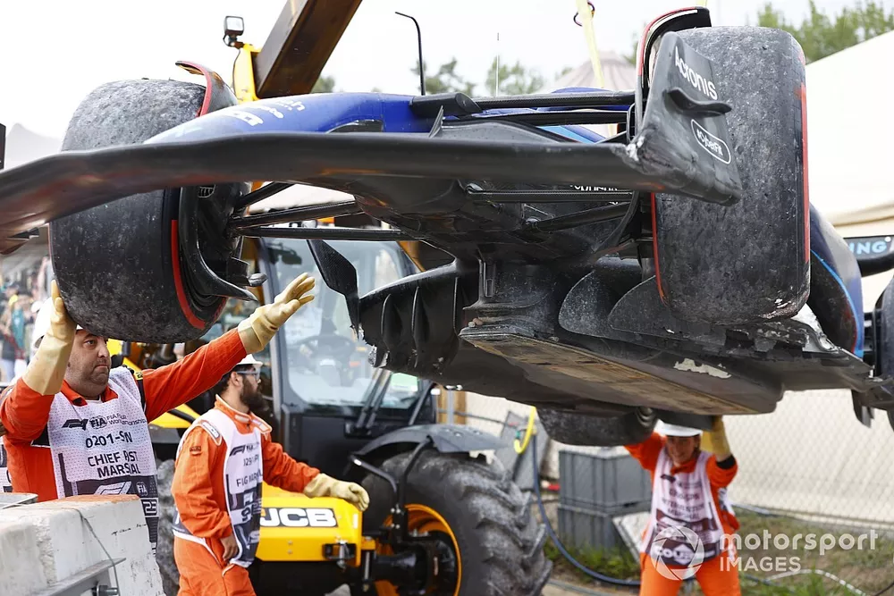 Marshals load the car of Logan Sargeant, Williams FW45, onto a truck after a crash in FP3