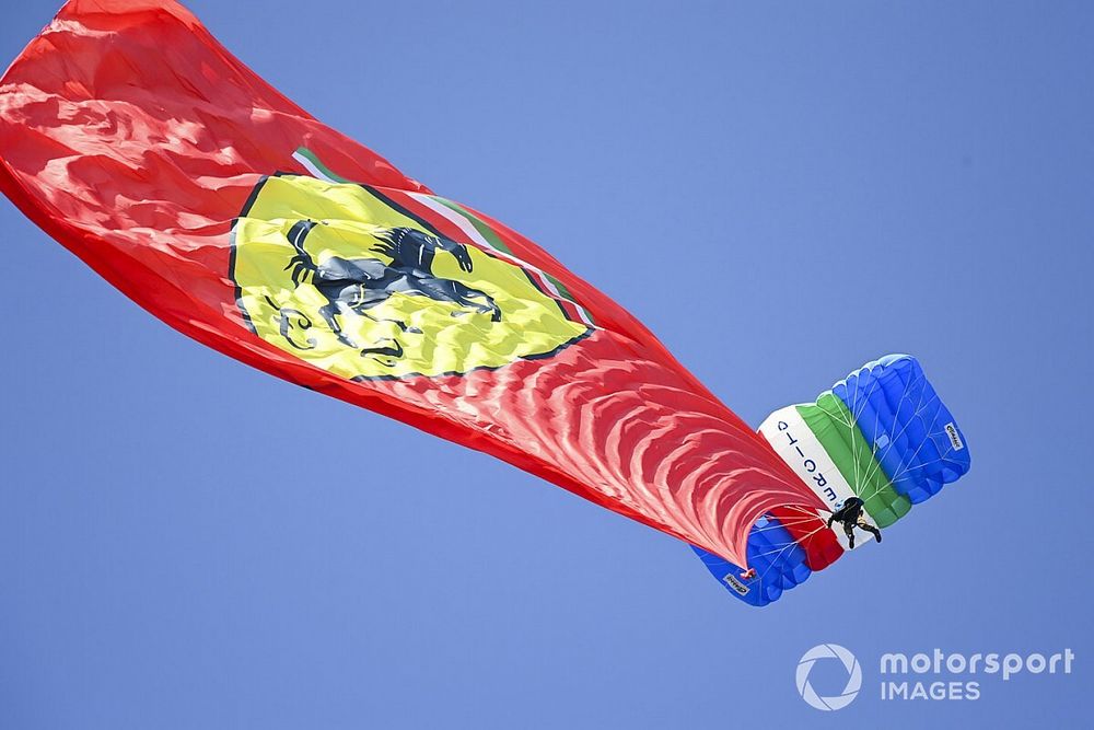 A Ferrari flag is trailed by a parachutist