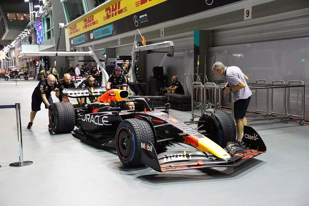 Mechanics work on the Max Verstappen Red Bull Racing RB18 in the pit lane