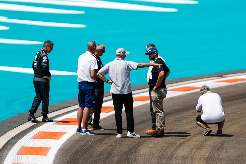 Oficiales, incluyendo a Niels Wittich, Director de Carrera, FIA, Bernd Maylander, conductor del coche de seguridad, inspeccionan la pista