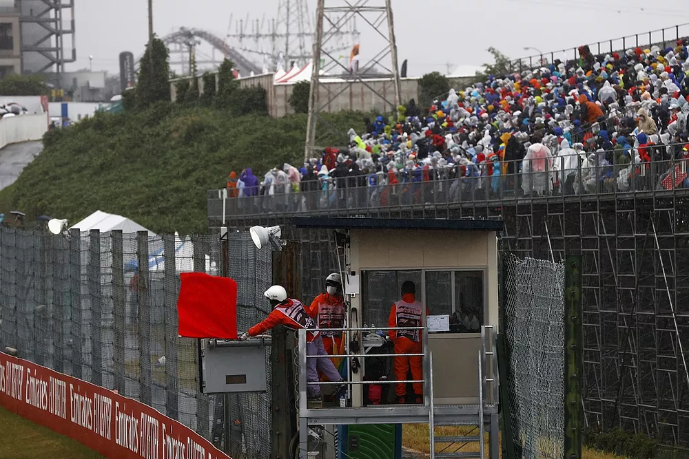 Oficiales de pista ondean la bandera roja