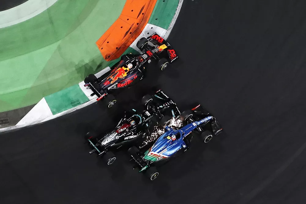 Max Verstappen, Red Bull Racing RB16B, Esteban Ocon, Alpine A521, and Lewis Hamilton, Mercedes W12, battle for the lead
