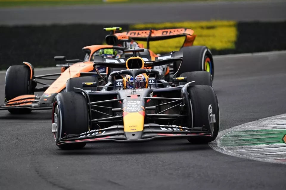Max Verstappen, Red Bull Racing RB20 defends from Lando Norris, McLaren MCL38 