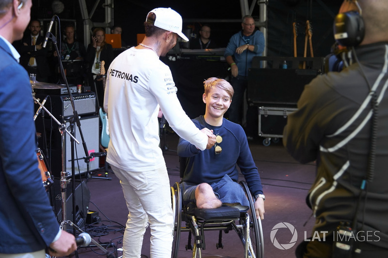 Lewis Hamilton, Mercedes AMG F1 en el escenario con con el piloto de British Formula 4 Billy Monger