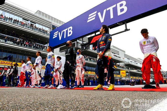 Los pilotos se colocan en la parrilla para escuchar el himno nacional antes de la salida