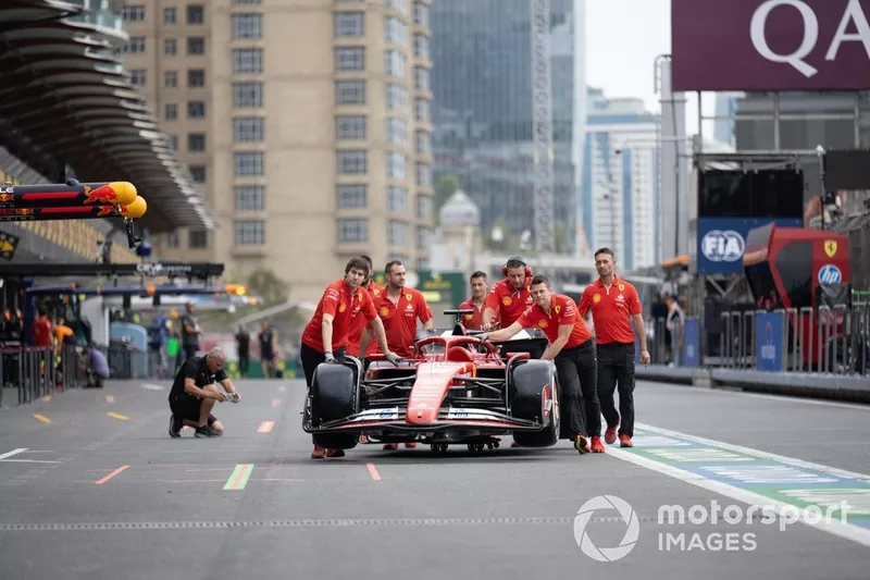 La voiture de Charles Leclerc, Ferrari SF-24, est descendue dans la voie des stands par les membres de l'équipe.