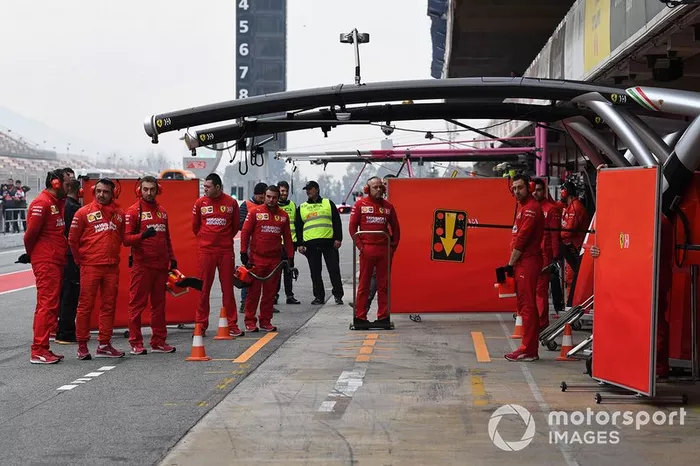 Mecánicos de Ferrari con paneles para tapar su coche de la vista de los curiosos