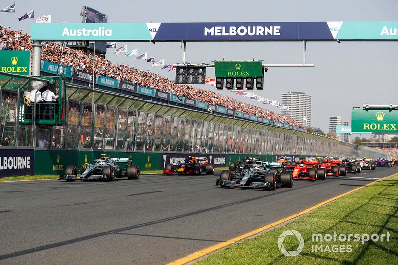 Красные огни гаснут и Льюис Хэмилтон, Mercedes AMG F1 W10, опережает Валттери Боттаса, Mercedes AMG W10, Себастьяна Феттеля, Ferrari SF90, Макса Ферстаппена, и остальную часть пелотона после старта