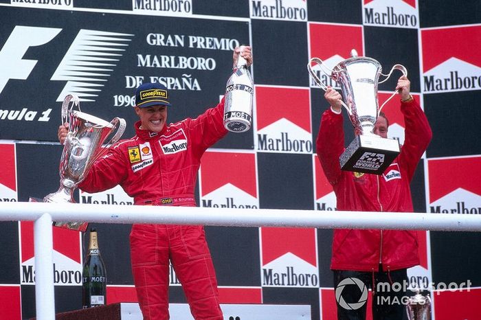 Michael Schumacher celebra su primera victoria para Ferrari en el podio con el jefe del equipo Jean Todt 