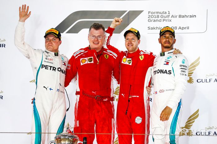Valtteri Bottas, Mercedes AMG F1, 2° classificato, Sebastian Vettel, Ferrari, 1° classificato, e Lewis Hamilton, Mercedes AMG F1, 3° classificato, sul podio con un membro del team Ferrari che riceve il trofeo Costruttori