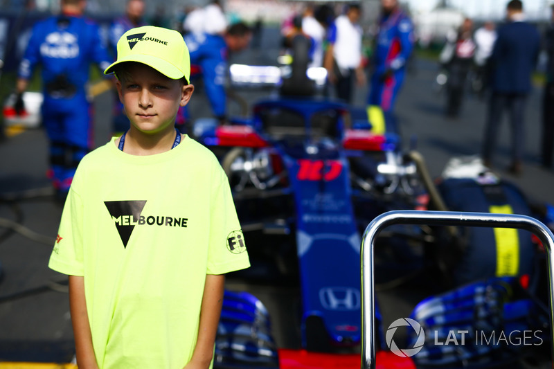 A Melbourne grid mascot in front of the car of Brendon Hartley, Toro Rosso