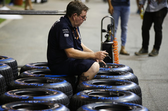 A Force India team member works on Pirelli tyres
