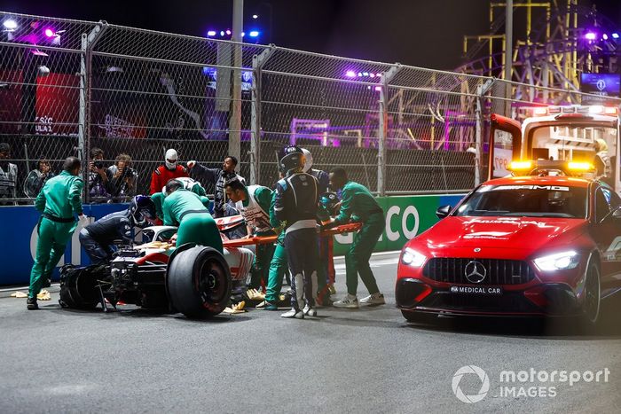 Los oficiales de pista recuperan los restos del coche dañado de Mick Schumacher, Haas VF-22, tras un fuerte accidente en la Q2  
