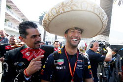 Daniel Ricciardo, Red Bull Racing, dons a sombrero, next to locals in traditional costume