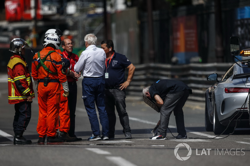Charlie Whiting, FIA Delegate oversees repairs to a loose drian cover that caused FP2 to be red flagged
