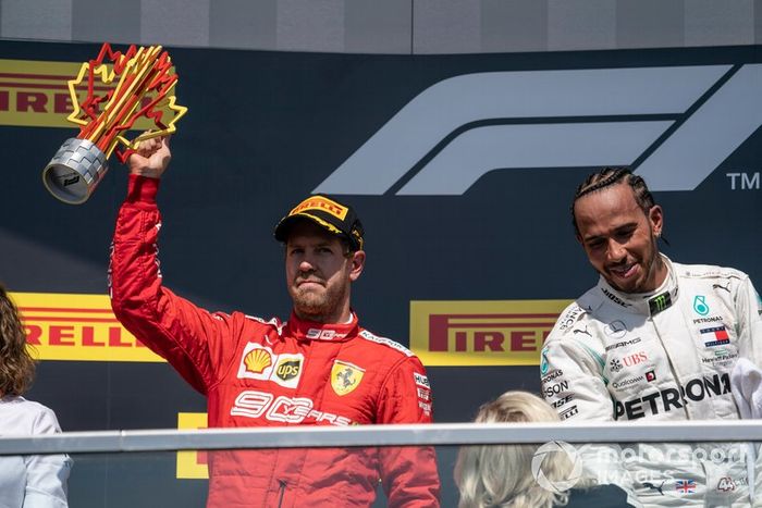 Sebastian Vettel, Ferrari, seconda posizione, solleva il suo trofeo sul podio