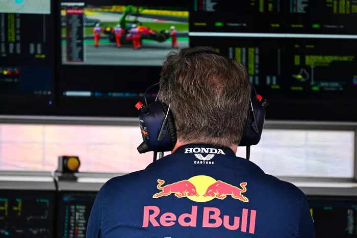 Christian Horner, Team Principal, Red Bull Racing, observa el coche de Sergio Pérez, Red Bull Racing RB19, siendo retirado por maeshals en el monitor del muro de boxes.