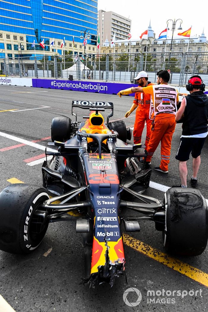 Oficiales de pista con el coche dañado de Max Verstappen, Red Bull Racing RB16B