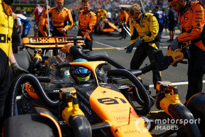Oscar Piastri, McLaren MCL38, en la parrilla con los mecánicos