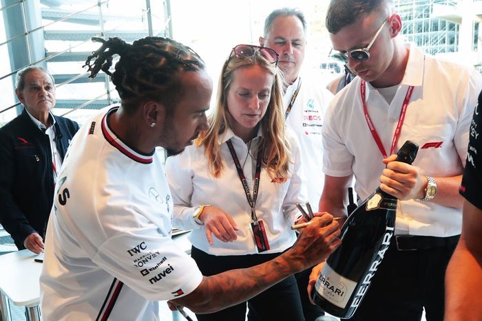 Lewis Hamilton y Mercedes firman una botella de champán Ferrari con fines benéficos