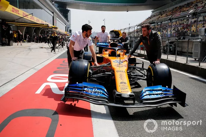 Los mecánicos de McLaren empujan el coche de Carlos Sainz Jr, McLaren MCL34, en el pit lane.