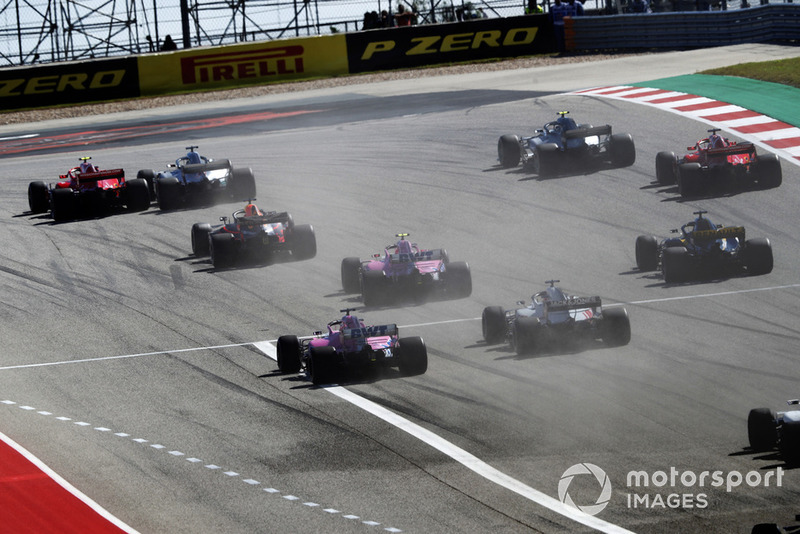 Kimi Raikkonen, Ferrari SF71H, passes Lewis Hamilton, Mercedes AMG F1 W09 EQ Power+, in the first turn as they lead the rest of the field at the start