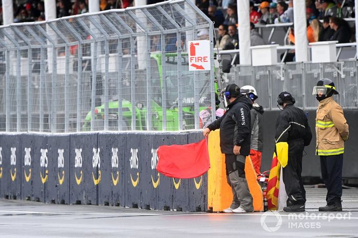Oficiales de pista despliegan la bandera roja en la calificación