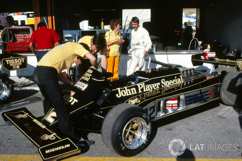 Nigel Mansell, talks to wife Roseanne Mansell, as mechanics work on his Lotus 87 in the pit area