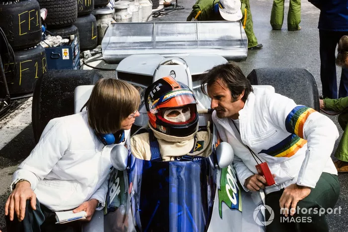 Emerson Fittipaldi talking to his brother Wilson in the pits, and designer Ricardo 'Richard' Divila