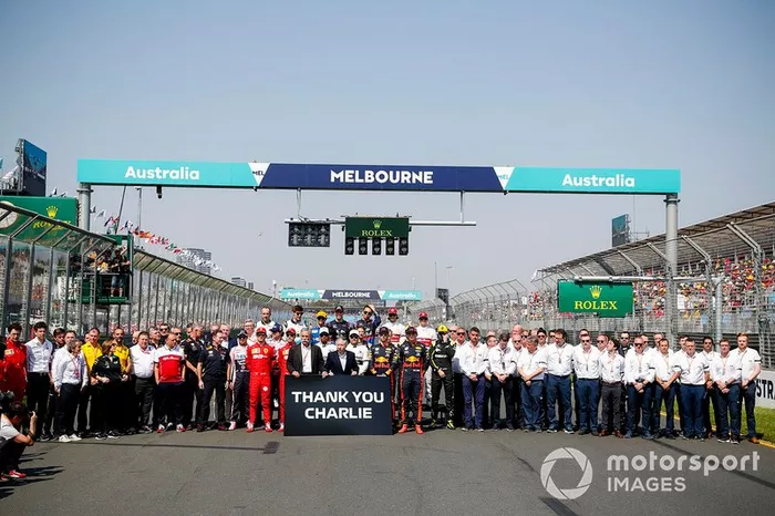 Los pilotos y el personal del equipo se reúnen detrás de Chase Carey, Presidente, Fórmula 1 y Jean Todt, Presidente, FIA, que sostienen un cartel que recuerda a Charlie Whiting.