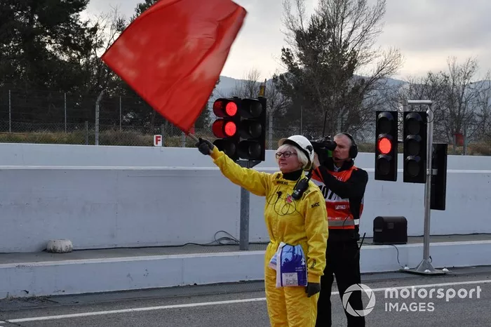 Un comisario con bandera roja