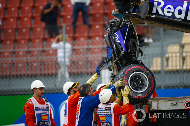 Marshals remove the damaged car of Brendon Hartley, Toro Rosso STR13, from the circuit as the gearbox hangs off the back