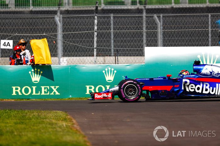 Brendon Hartley, Scuderia Toro Rosso STR12, detenido en pista en los PL1, un mariscal muestra una bandera amarilla