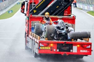 Un comisario con el coche dañado de Logan Sargeant, Williams FW46, en un camión