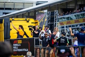 Lando Norris, da McLaren F1 Team, acena para o público, enquanto Lewis Hamilton, da Mercedes-AMG F1 Team, grava com uma câmara de vídeo durante a parada dos pilotos 