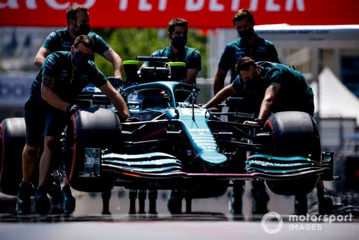 Los mecánicos mueven el coche de Lance Stroll, Aston Martin AMR21