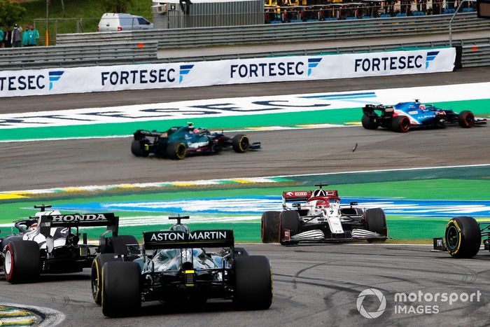 Esteban Ocon, Alpine A521, Sebastian Vettel, Aston Martin AMR21, mientras Kimi Raikkonen, Alfa Romeo Racing C41, hace un trompo en la primera vuelta