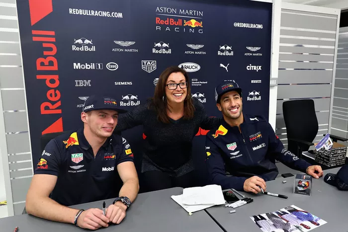 Daniel Ricciardo, Red Bull Racing, y Max Verstappen, Red Bull Racing, posan para una foto con un miembro de Red Bull Racing