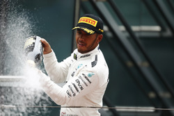 Lewis Hamilton, Mercedes AMG, celebrates victory by spraying chamagne on the podium